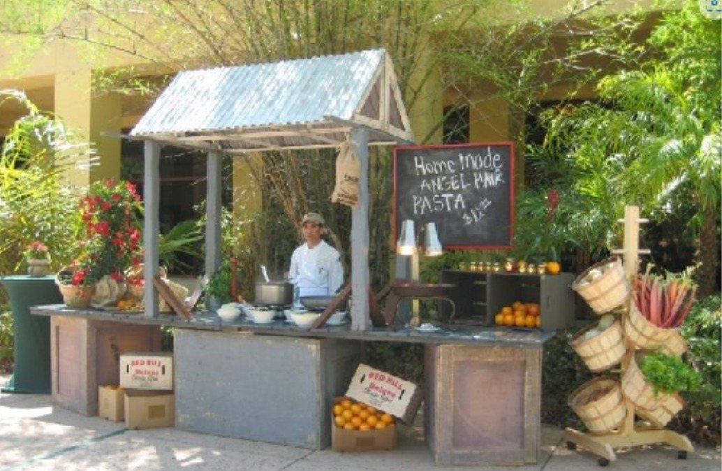 Thatched marketplace food station with chalkboard menu