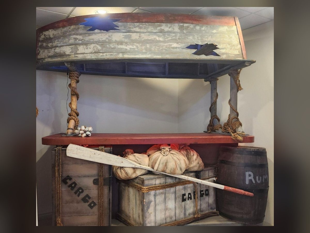 Weathered shipwreck-themed bar with oars and crates