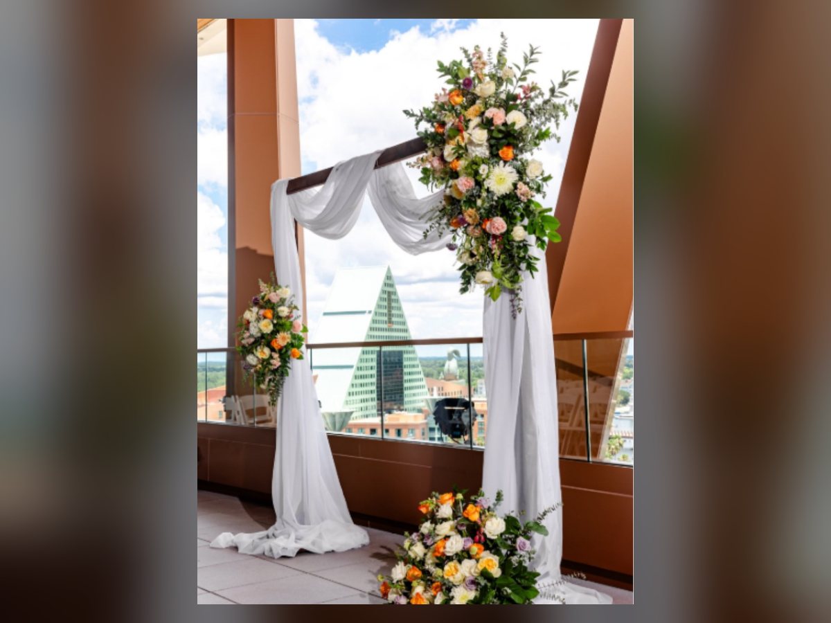 Wooden ceremony arch with draping and florals
